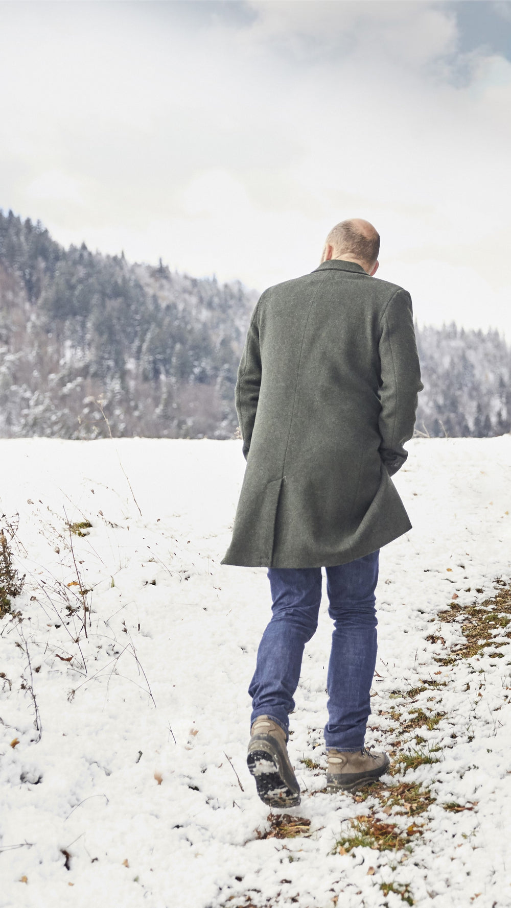 Frédéric Revol, fondateur des Hautes Glaces, arpente un champs enneigé où poussent les céréales permettant l'élaboration de nos whisky et eau de vie d'exceptions.