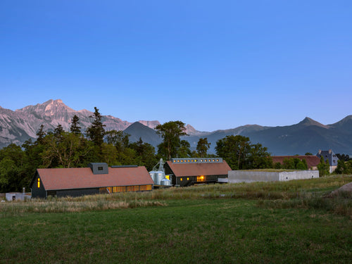 Distillerie, malterie et chai de vieillissement des Hautes Glaces, sur fond de montagnes alpines : la chaine de l'Obiou.