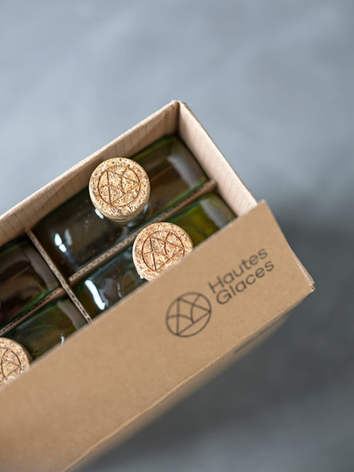 Un carton de livraison laisse apparaître nos nouveaux flacons, à la forme compacte et aux bouchons en "drêches" d'orge de la distillerie.