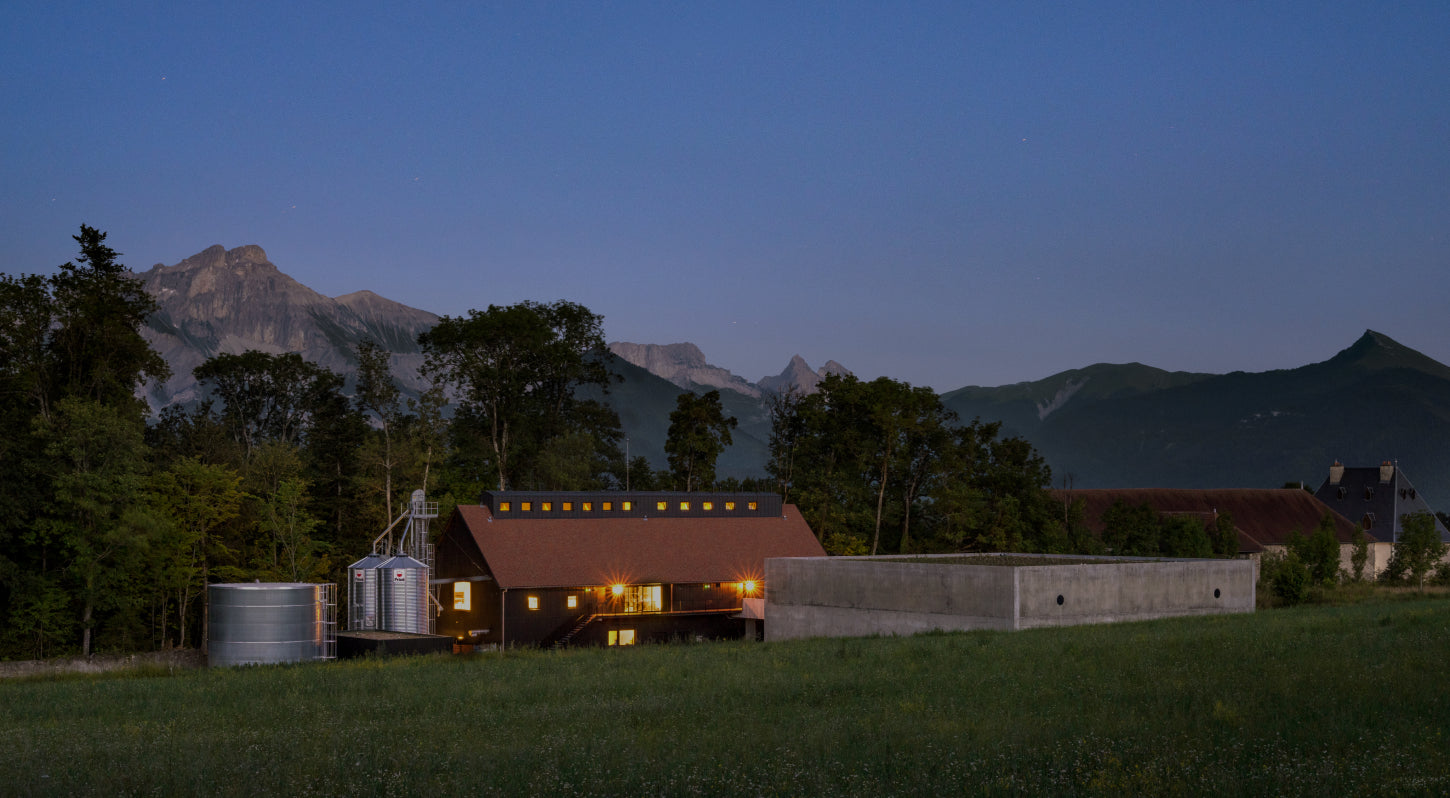 Image de la distillerie du Domaine de Hautes Glaces avec les arbres et vue sur montagnes